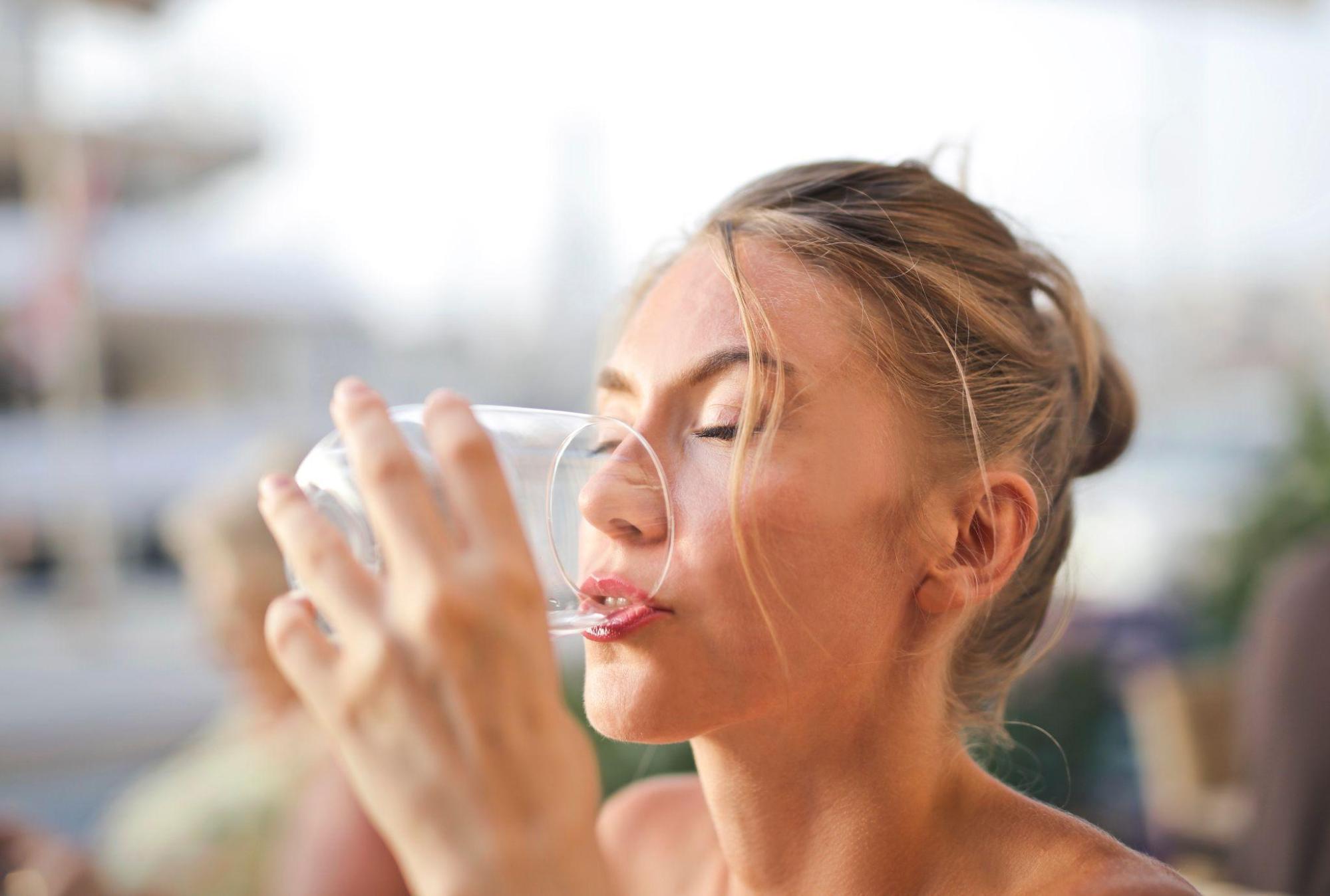  A woman drinking a glass of water.